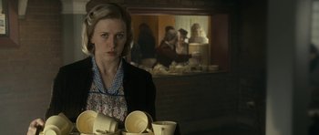 Movie still from “The Iron Lady” (2011), directed by Phyllida Lloyd – A woman in a kitchen holding a tray of dishes; Close Up shot, Over the shoulder angle