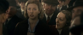 Movie still from “The Iron Lady” (2011), directed by Phyllida Lloyd – A group of people standing next to each other on a train; Close Up shot, Over the shoulder angle