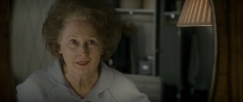 Movie still from “The Iron Lady” (2011), directed by Phyllida Lloyd – An older woman is smiling for the camera; Close Up shot, Over the shoulder angle