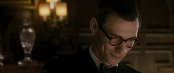 Movie still from “The Iron Lady” (2011), directed by Phyllida Lloyd – A person wearing glasses and a suit; Close Up shot, Over the shoulder angle