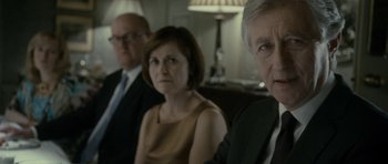 Movie still from “The Iron Lady” (2011), directed by Phyllida Lloyd – A group of three people sitting in a room together; Close Up shot, Over the shoulder angle