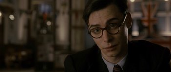 Movie still from “The Iron Lady” (2011), directed by Phyllida Lloyd – A person wearing a suit and glasses; Close Up shot, Over the shoulder angle