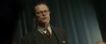 Movie still from “The Iron Lady” (2011), directed by Phyllida Lloyd – A man in a suit and tie standing in front of a curtain; Close Up shot, Low angle