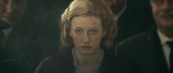 Movie still from “The Iron Lady” (2011), directed by Phyllida Lloyd – A person wearing a suit and tie; Close Up shot, Over the shoulder angle