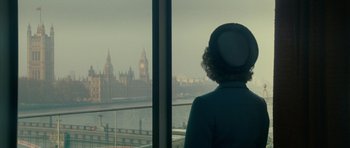 Movie still from “The Iron Lady” (2011), directed by Phyllida Lloyd – A woman looking out of a window at a city skyline; Wide shot, Low angle