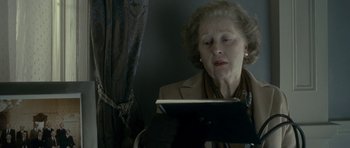 Movie still from “The Iron Lady” (2011), directed by Phyllida Lloyd – An older woman is looking at a computer screen; Close Up shot, Low angle