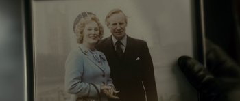 Movie still from “The Iron Lady” (2011), directed by Phyllida Lloyd – An old photo of an older man and woman; Close Up shot, Low angle