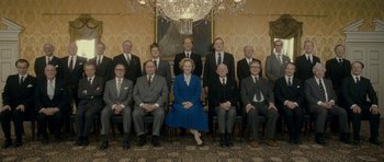 Movie still from “The Iron Lady” (2011), directed by Phyllida Lloyd – A group of men and a woman sitting in front of a chandelier; Wide shot, Low angle