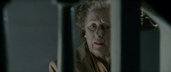 Movie still from “The Iron Lady” (2011), directed by Phyllida Lloyd – An older woman looking at the camera through a window; Close Up shot, Over the shoulder angle