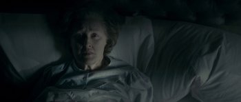 Movie still from “The Iron Lady” (2011), directed by Phyllida Lloyd – An older woman laying in a bed in a dark room; Close Up shot, High angle