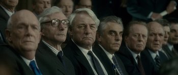Movie still from “The Iron Lady” (2011), directed by Phyllida Lloyd – A group of men in suits and ties sitting next to each other; Close Up shot, Over the shoulder angle