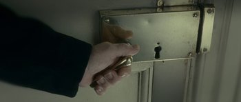 Movie still from “The Iron Lady” (2011), directed by Phyllida Lloyd – A hand holding a door knob on a door knob; Extreme Close Up shot, High angle
