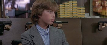 Movie still from “The Island” (1980), directed by Michael Ritchie – A young man in a suit and tie; Close Up shot, Over the shoulder angle