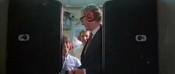 Movie still from “The Island” (1980), directed by Michael Ritchie – A group of people wearing ear muffs on a train; Medium shot, Over the shoulder angle