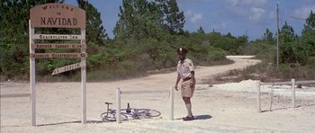 Movie still from “The Island” (1980), directed by Michael Ritchie – A police officer standing in front of a bicycle and a fence; Wide shot, High angle