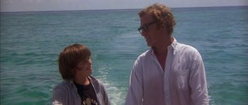 Movie still from “The Island” (1980), directed by Michael Ritchie – A man standing next to a boy in the ocean; Medium shot, Over the shoulder angle