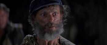 Movie still from “The Island” (1980), directed by Michael Ritchie – An old man with a long beard wearing a hat; Close Up shot, Low angle