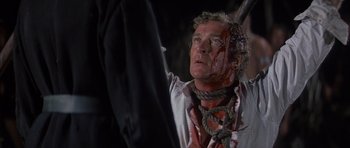 Movie still from “The Island” (1980), directed by Michael Ritchie – A man with a rope around his neck and face; Close Up shot, Over the shoulder angle