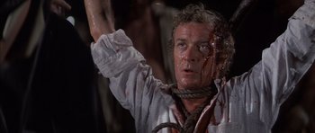 Movie still from “The Island” (1980), directed by Michael Ritchie – A person with blood on their face; Close Up shot, High angle