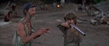 Movie still from “The Island” (1980), directed by Michael Ritchie – A man and a boy are playing with a toy gun; Medium shot, Over the shoulder angle
