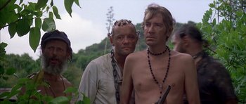 Movie still from “The Island” (1980), directed by Michael Ritchie – A man and a woman standing next to each other in chains; Medium shot, Low angle