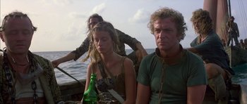 Movie still from “The Island” (1980), directed by Michael Ritchie – A group of people sitting on a boat in the water; Medium shot, Low angle