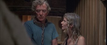 Movie still from “The Island” (1980), directed by Michael Ritchie – A man and a woman standing next to each other; Close Up shot, Over the shoulder angle