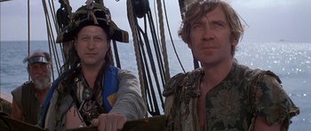 Movie still from “The Island” (1980), directed by Michael Ritchie – Two men in pirate costumes on a boat; Medium shot, Low angle