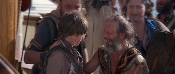 Movie still from “The Island” (1980), directed by Michael Ritchie – An older man and a young boy are smiling together; Medium shot, Over the shoulder angle