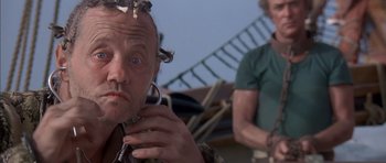 Movie still from “The Island” (1980), directed by Michael Ritchie – A man with a bunch of snakes on his head; Close Up shot, Low angle