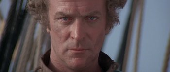 Movie still from “The Island” (1980), directed by Michael Ritchie – A man's face with blue eyes; Close Up shot, Low angle