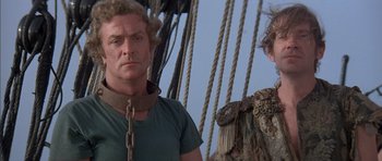Movie still from “The Island” (1980), directed by Michael Ritchie – A man standing next to another man on a boat; Close Up shot, Low angle