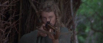 Movie still from “The Island” (1980), directed by Michael Ritchie – A woman holding a rifle in front of her face; Close Up shot, High angle