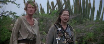 Movie still from “The Island” (1980), directed by Michael Ritchie – A man and a woman standing next to each other; Close Up shot, Low angle