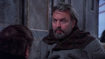 Movie still from “The Island at the Top of the World” (1974), directed by Robert Stevenson – A man with a beard and a scarf around his neck; Close Up shot, Over the shoulder angle