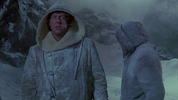 Movie still from “The Island at the Top of the World” (1974), directed by Robert Stevenson – A man in a hooded jacket standing next to another man; Medium shot, Over the shoulder angle