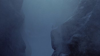 Movie still from “The Island at the Top of the World” (1974), directed by Robert Stevenson – A man standing on a cliff in the middle of the ocean; Extreme Wide shot, Low angle
