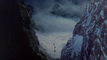 Movie still from “The Island at the Top of the World” (1974), directed by Robert Stevenson – A group of skiers are going down a snowy mountain; Extreme Wide shot, High angle