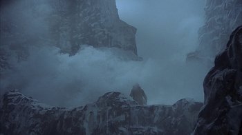Movie still from “The Island at the Top of the World” (1974), directed by Robert Stevenson – A man standing on top of a mountain in the fog; Extreme Wide shot, Low angle