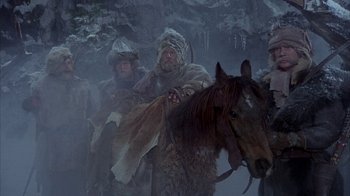 Movie still from “The Island at the Top of the World” (1974), directed by Robert Stevenson – A group of men in fur coats are walking through the snow; Wide shot, Low angle