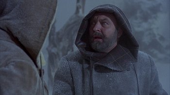 Movie still from “The Island at the Top of the World” (1974), directed by Robert Stevenson – A man in a hooded jacket looking up at the sky; Close Up shot, Low angle