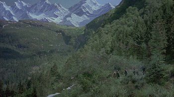 Movie still from “The Island at the Top of the World” (1974), directed by Robert Stevenson – A group of people walking up a mountain side; Extreme Wide shot, High angle