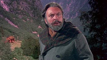 Movie still from “The Island at the Top of the World” (1974), directed by Robert Stevenson – An older man with a beard and mustache wearing a coat; Close Up shot, Low angle