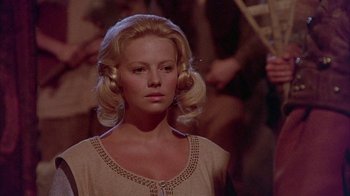 Movie still from “The Island at the Top of the World” (1974), directed by Robert Stevenson – A woman with blonde ringlets is looking at the camera; Close Up shot, Over the shoulder angle