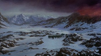 Movie still from “The Island at the Top of the World” (1974), directed by Robert Stevenson – A group of people walking across a snow covered field; Extreme Wide shot, High angle