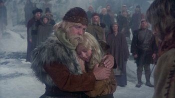 Movie still from “The Island at the Top of the World” (1974), directed by Robert Stevenson – A man and a woman hugging in the snow; Medium shot, High angle