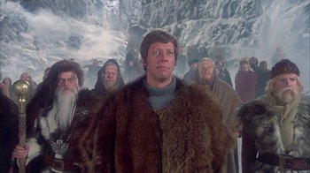 Movie still from “The Island at the Top of the World” (1974), directed by Robert Stevenson – A group of people in fur coats standing next to each other in the snow; Medium shot, Low angle