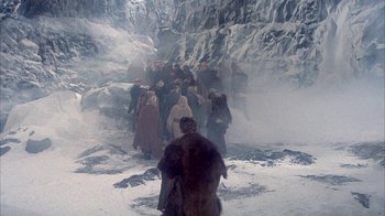 Movie still from “The Island at the Top of the World” (1974), directed by Robert Stevenson – A group of people walking through the snow; Extreme Wide shot, High angle