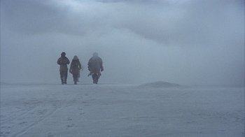 Movie still from “The Island at the Top of the World” (1974), directed by Robert Stevenson – A group of people walking on a snowy slope; Wide shot, High angle