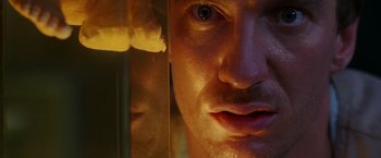 Movie still from “The Island of Dr. Moreau” (1996), directed by Richard Stanley – A man's face in front of a mirror; Extreme Close Up shot, Low angle
